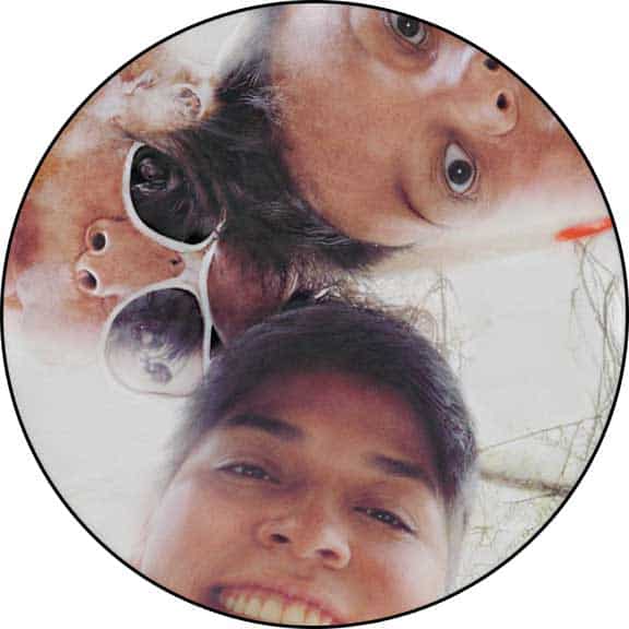 Three people, including Kristin Hoffman, are looking down at the camera—two at the top and one at the bottom—with one wearing white sunglasses. The image is circularly cropped.