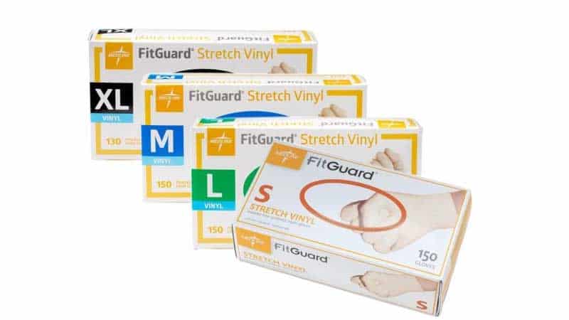 Four boxes of FitGuard Stretch Vinyl gloves in sizes XL, M, L, and S are displayed in a row, with each box containing either 130 or 150 gloves.